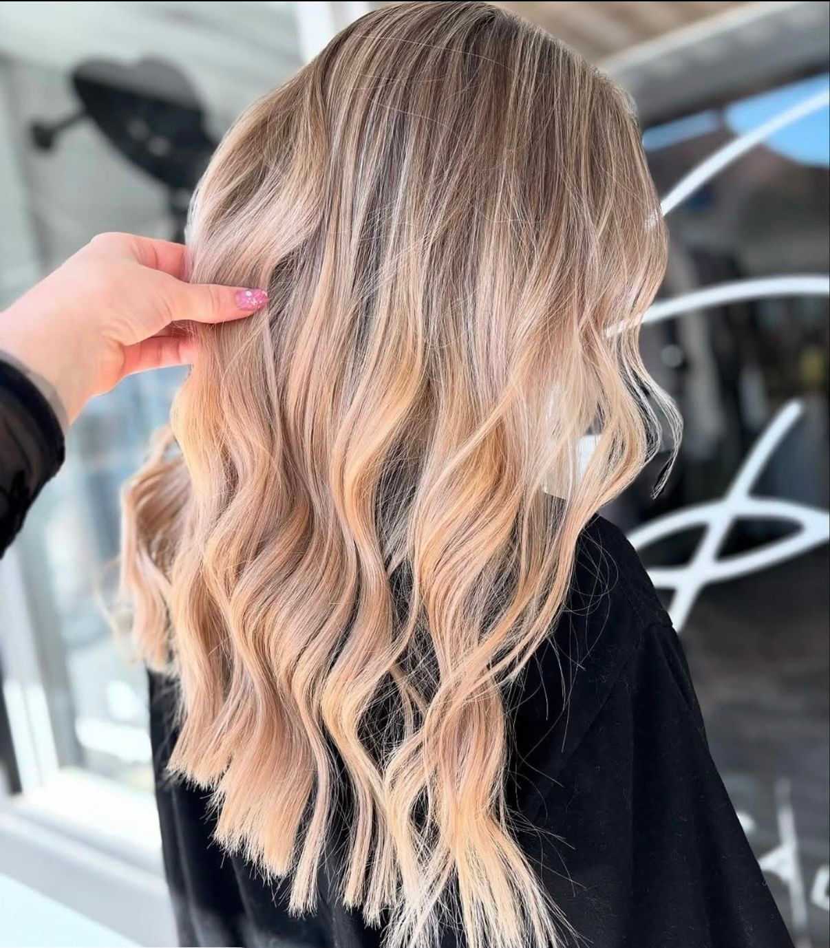 Blonde hair with soft waves styled in a salon.
