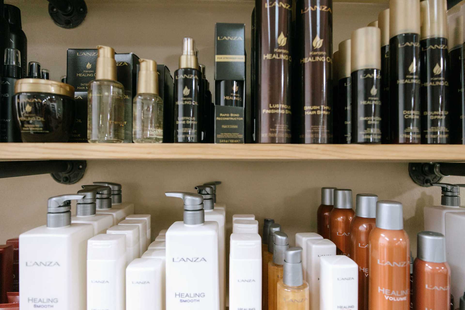 Shelf stocked with L'ANZA hair care products, including shampoos, conditioners, and sprays.